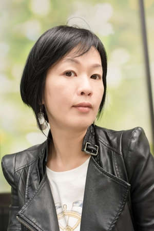Asian mature woman at street, closeup portrait.