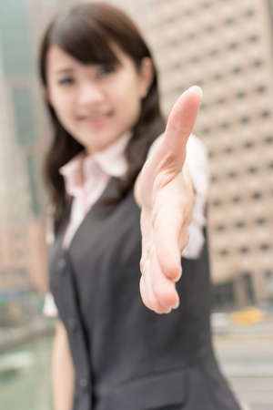 Business woman shake hand with you, closeup portrait in city.の写真素材