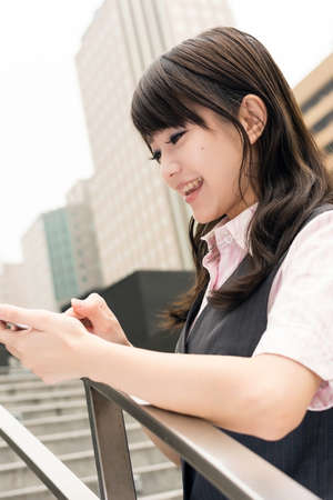 Business woman use smartphone in outside of modern city.の写真素材