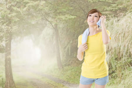 Smiling jogging woman take a rest after training, closeup portrait at mist forest.の写真素材