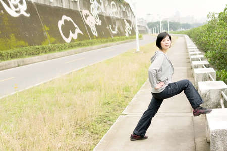 Mature woman of Asian stretch her body in outdoor park.の写真素材