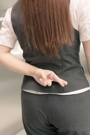 Rear view of Asian business woman gesture an fake sign.の写真素材