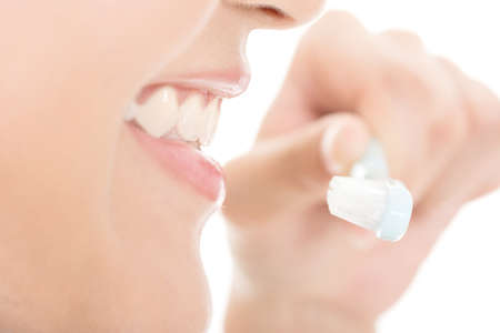Closeup shot of woman brushing teeth. Profile view.