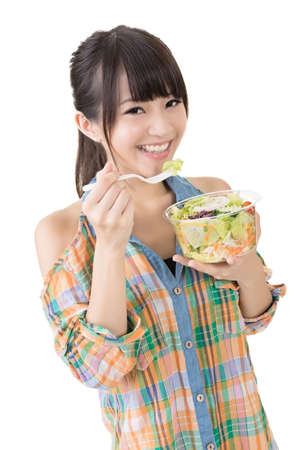 Asian pretty woman eats salad. Close up portrait. Isolated on the white background.の写真素材