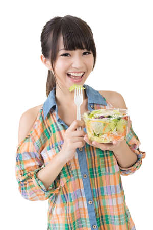 Asian pretty woman eats salad. Closeup portrait. Isolated on the white background.の写真素材