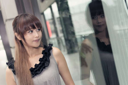 Asian woman shopping and stand in front of the store in a mall in Taipei, Taiwan, Asia.の写真素材
