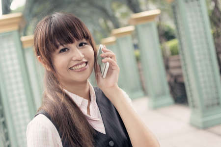 Attractive business woman use cellphone, portrait in outside, Taipei, Taiwan, Asia.の写真素材