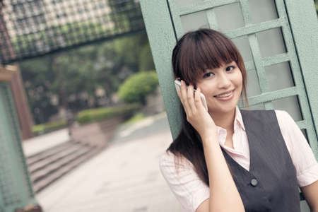 Attractive business woman use cellphone, portrait in outside, Taipei, Taiwan, Asia.の写真素材