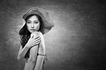Attractive sexy asian lady in bikini with hat. Black and white photo.の写真素材