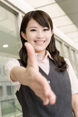 Business woman shake hand with you, closeup portrait in city.の写真素材