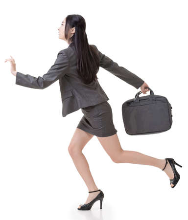 Asian businesswoman run and hold a briefcase, side view full length portrait isolated on white background.の写真素材
