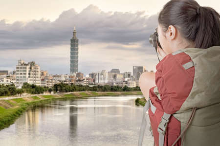 Young backpacker travel and take picture, the tower is the famous landmark, 101 skyscraper, Taipei, Taiwan のeditorial素材