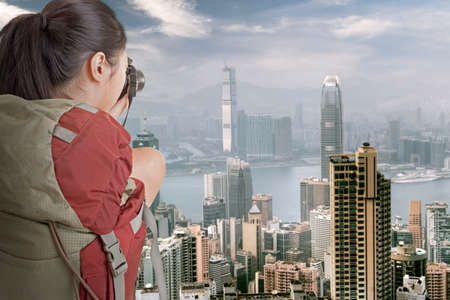 Young backpacker travel and take picture at Hong Kong with famous skyscrapers in daytime のeditorial素材