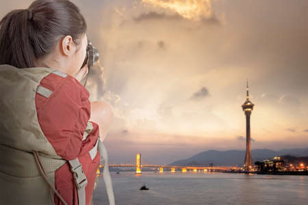 Young backpacker travel and take picture at Macau with famous travel tower のeditorial素材