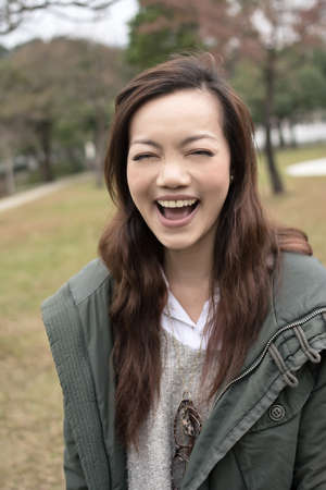 Happy smiling Asian young woman in the park, Taipei, Taiwan.の写真素材