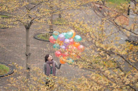 Young woman playing and holding balloons at park in Taipei, Taiwan, Asia.の写真素材