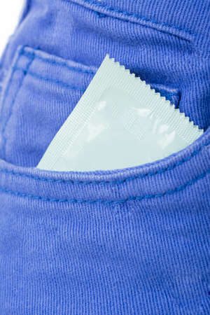 Pulling a condom in the pocket of blue jeansの写真素材