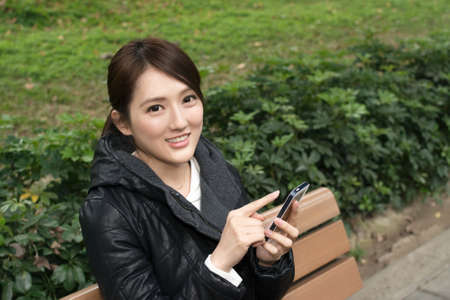 Attractive young Asian woman using smartphone, closeup portrait.の写真素材