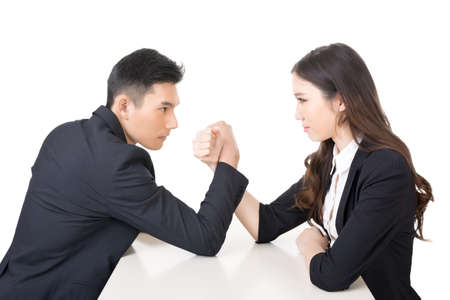 Arm wrestling challenge between a young business man and woman, closeup portrait on white background.の写真素材