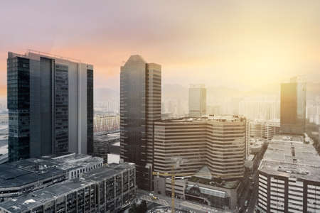 Sunset cityscape with modern skyscrapers under dramatic sky in Hong Kongの写真素材