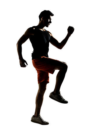 Silhouette of young Asian athlete running, full length portrait isolated on white の写真素材