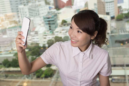 Business woman selfie near the window in hotel room.の写真素材