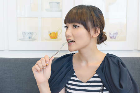 Asian woman eat lunch with funny face.の写真素材