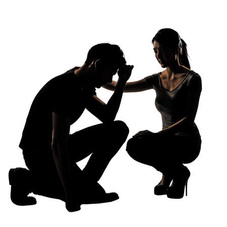 Silhouette of one sad Asian man squat and his wife give comfort to him, full length portrait isolated on white background.の写真素材