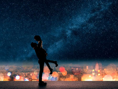 Silhouette of Asian couple, man hold his girlfriend up above the city in night under stars.