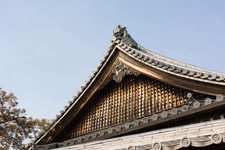Wooden roof in traditional Japanese wooden style with blue sky.