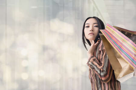Elegant Asian woman shopping, closeup portrait.の写真素材