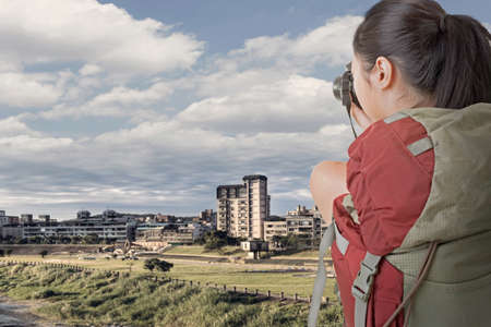 Asian female backpacker take photo in the city.の写真素材