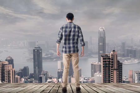 Asian man standing and looking the skyline of the Hong kong city, Asia.の写真素材