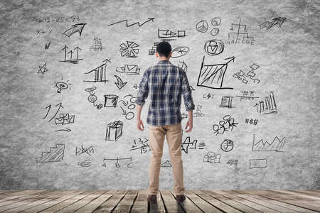 Man with disorderly business plan on wall.の写真素材