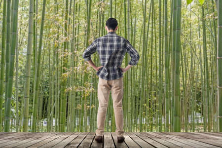 Man standing and looking into the bamboo forest, concept of relax, freedom, zen etc.の写真素材
