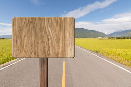 Blank wooden sign on field of farm. Concept of rural, idyllic, tranquility etc.の写真素材