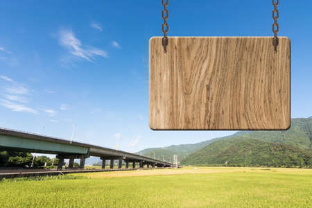 Blank wooden sign on field of paddy farm. Concept of rural, idyllic, tranquility etc.