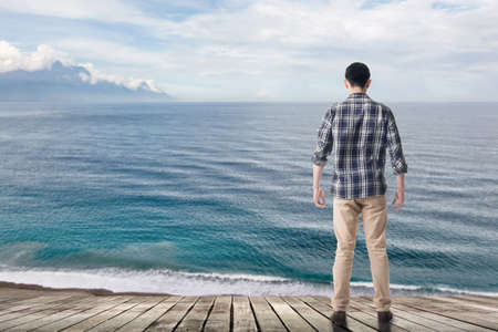 Man standing and looking the ocean, concept of relax, freedom etc.の写真素材