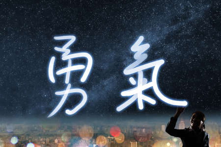 Concept of courage, silhouette asian business woman light drawing. The chinese words means "courage".の写真素材