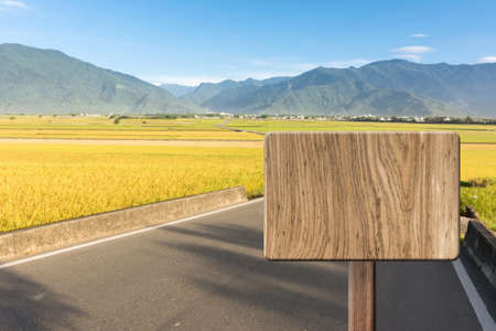 Blank wooden sign on field of farm. Concept of rural, idyllic, tranquility etc.の写真素材