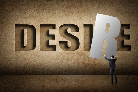 Concept of desire, asian business man with hold a word to fill the wall.の写真素材