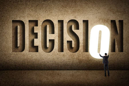 Concept of target, choice, decisioin etc with asian business man and 3D text on wall.の写真素材