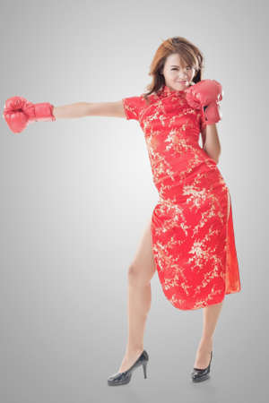 Chinese woman dress traditional cheongsam and boxing gloves, full length portrait isolated.の写真素材