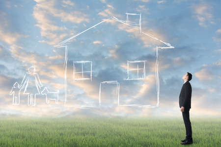 Asian man look toward the drawing house and family in the heaven.の写真素材