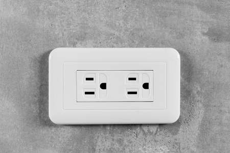 Socket, electrical outlet on gray wall. Close-up image.