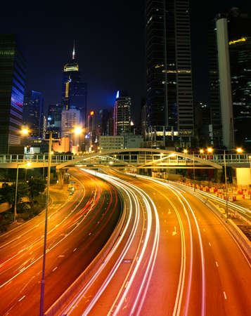 Colorful city night scene with modern skyscrapers and cars motion blurred in Hong Kong, Asia.の写真素材