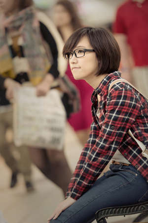 Shopping young girl of Asian sit at bench at mall in Taipei, Taiwan.の写真素材