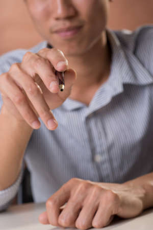 Business man holding pen and pointing at you.の写真素材