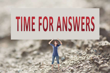 Time for answers, words on blank board hold by a young girl in the outdoor.の写真素材