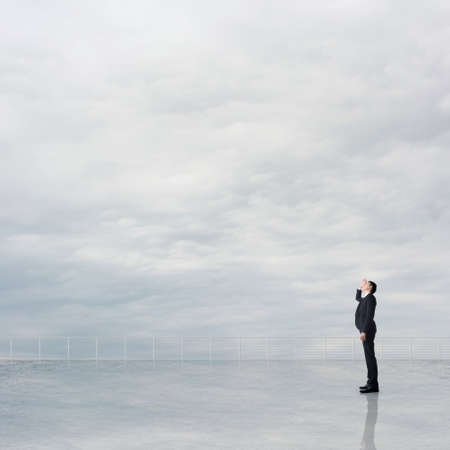 Man look and discover against the cloudy sky with copyspace.の写真素材